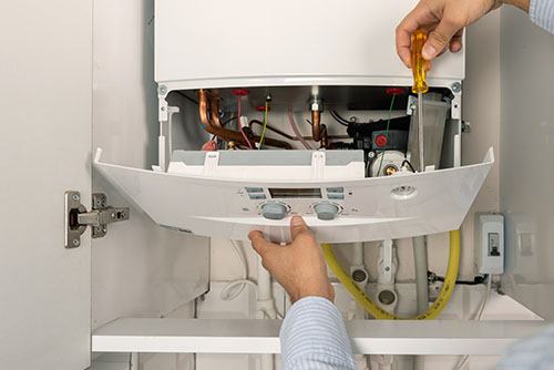 HVAC technician repairing an indoor boiler in Greeley