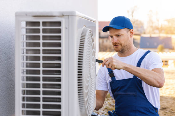HVAC technician servicing an outdoor air conditioning unit in Greeley