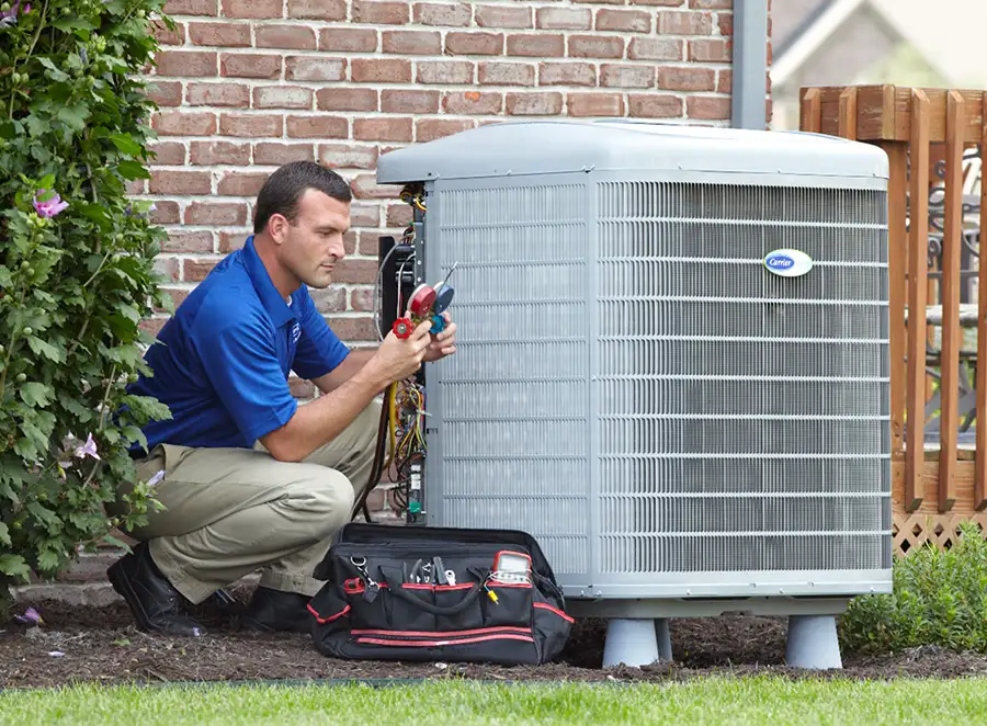 HVAC technician inspecting an outdoor air conditioning unit in Greeley