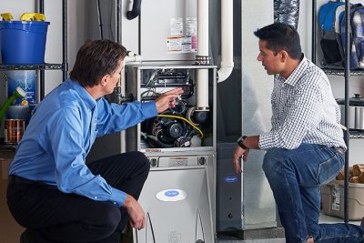 HVAC technician explaining furnace repair and maintenance to a homeowner in Greeley, CO