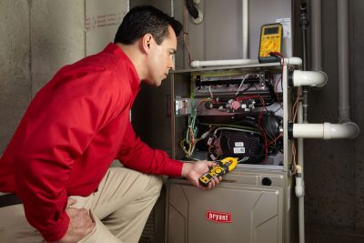 Heating and air conditioning technician servicing an indoor furnace in Greeley, CO